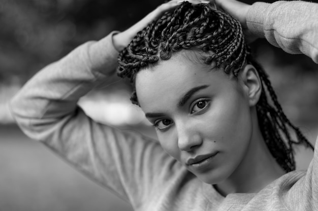 Un portrait en noir et blanc d'une belle fille avec des tresses tressées