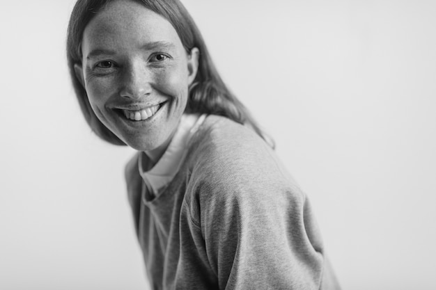 Portrait noir et blanc d'une femme souriante avec des taches de rousseur