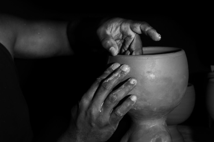 Photo portrait en noir et blanc en gros plan de mains d'artisans façonnant des pots de céramique art de l'argile