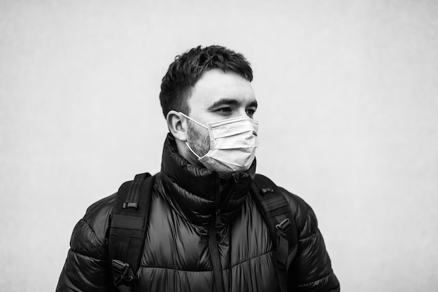 Portrait en noir et blanc d'un homme dans un masque d'un virus. Protection contre Covid-19. Quarantaine dans la ville.