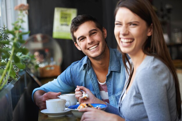 Portrait de nourriture et de couple heureux mangeant dans un café riant et se liant ensemble le jour de la Saint-Valentin rendez-vous le matin visage sourire homme et femme dans le restaurant avec le petit déjeuner café amour et relation