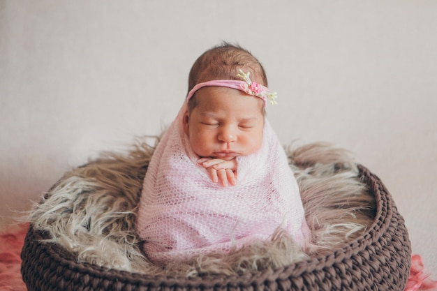 portrait d'un nouveau-né endormi dans un bandeau avec fleur. Concept santé: FIV, accessoires bébé