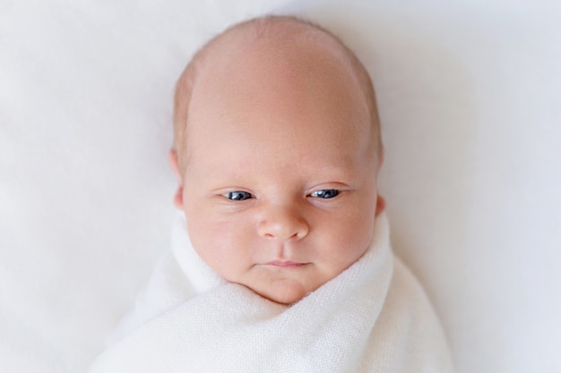 Photo portrait d'un nouveau-né avec les yeux ouverts sur blanc