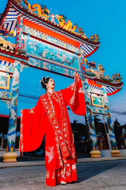 Portrait de nouvelle année d'une femme en costume traditionnel, d'une belle jeune femme en robe rouge vif et d'une couronne de reine chinoise.