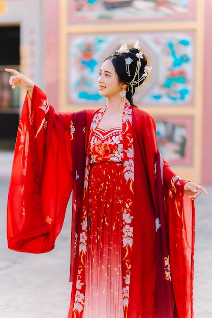 Portrait de nouvelle année d'une femme en costume traditionnel, d'une belle jeune femme en robe rouge vif et d'une couronne de reine chinoise.