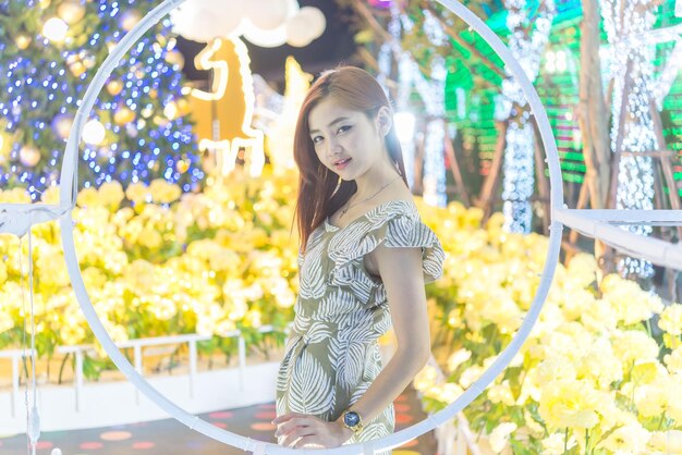 Portrait de nuit d'une belle femme asiatiqueThaïlande fille pose pour prendre une photo sur la lumière bokeh la nuit