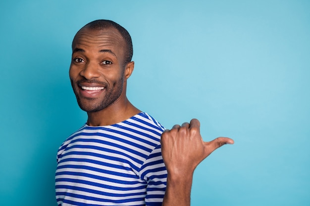 Portrait of afro american guy point thumb copyspace isolé sur fond bleu