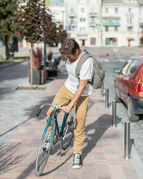 Portrait of casual male riding bike à l'extérieur