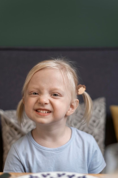 Portrait of cute blonde girl with two tails Threeyearold girl sourit à la caméra et fronce le nez