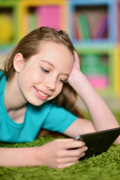 Portrait of cute girl with digital tablet on floor