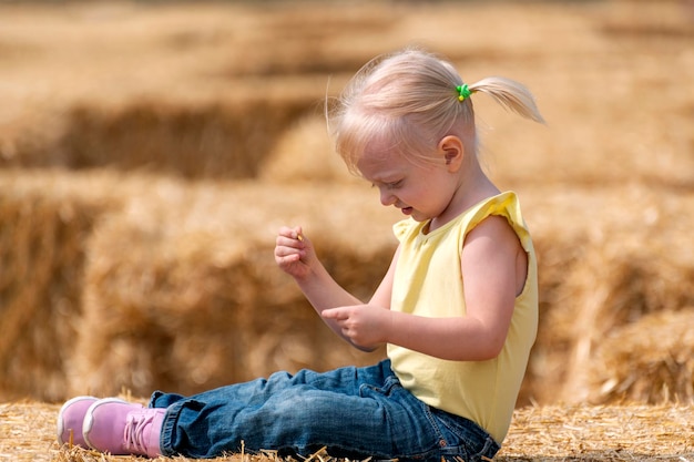 Portrait of cute happy little girl on haystack Enfance à la ferme Récolte du foin