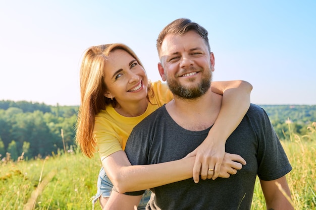 Portrait of happy adult hugging couple sur une journée ensoleillée d'été