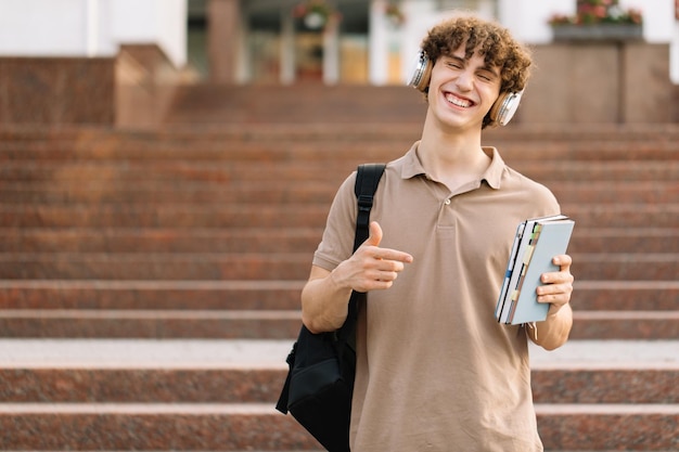 Portrait Of Happy Attractive Male Student Holding Books Et Passé D'excellents Examens à L'université
