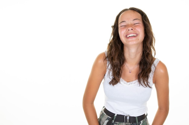 Portrait of happy brunette surpris jeune femme adolescent sourire rire les yeux fermés sur fond blanc