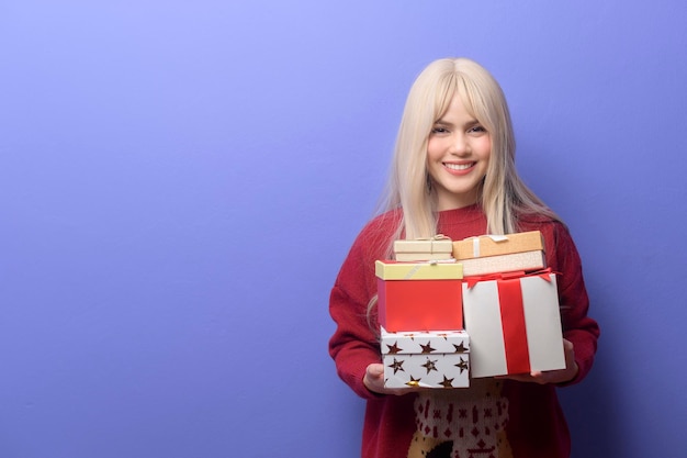 Portrait of happy Caucasian young woman with gift box sur fond violet