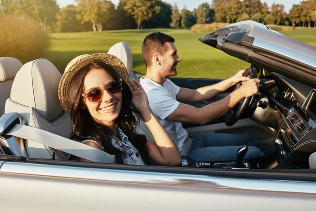 Portrait of happy couple driving cabriolet en été