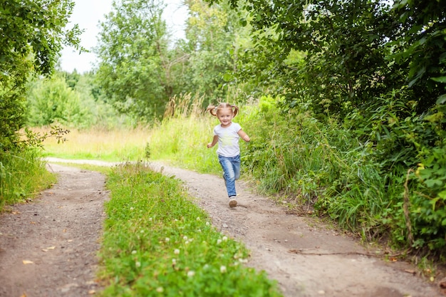 Portrait of happy cute little girl palying en plein air en cours d'exécution dans le parc