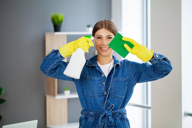 Portrait of happy female cleaner avec équipement de nettoyage au bureau