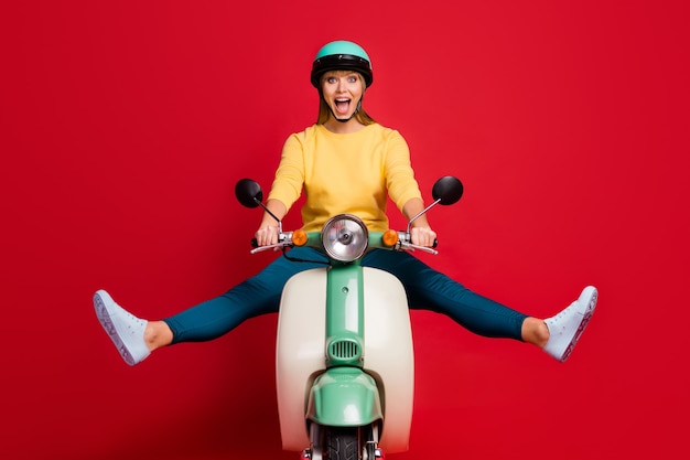 Portrait of happy girl conduisant un cyclomoteur crier bouche ouverte