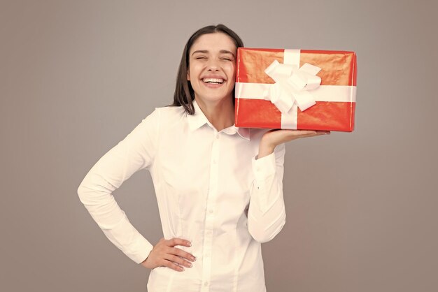 Portrait of a happy girl with gift box isolé sur fond gris Woman holding gift present