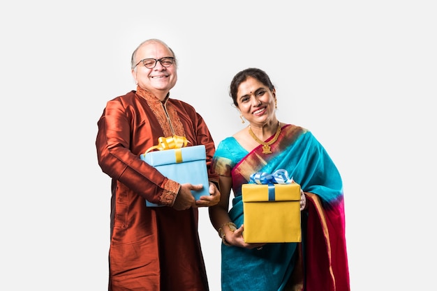 Portrait of Happy Indian asiatique senior ou couple de retraités tenant des coffrets cadeaux isolés sur fond blanc