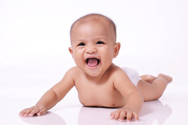 Portrait of happy little baby asiatique sourire fille face vers le bas sur le sol blanc isolé sur mur blanc