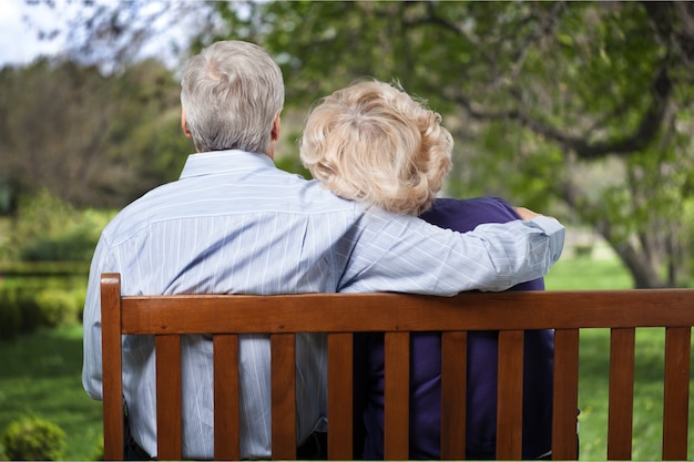 Portrait of happy senior couple sur banc