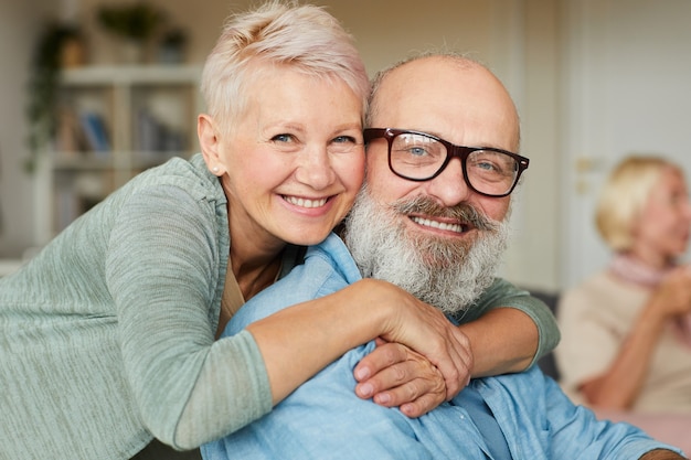 Portrait of happy senior couple embrassant et souriant à la caméra