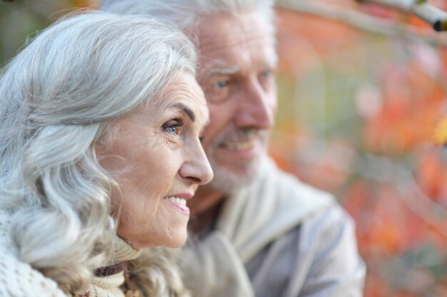 Portrait of happy senior couple in autumn park