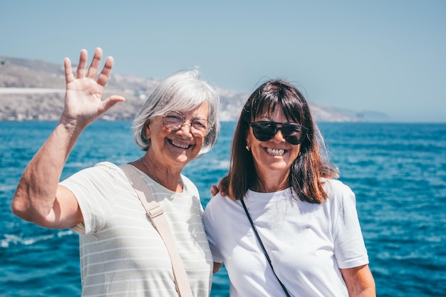 Portrait of happy senior couple of females profitant des vacances d'été ensemble en mer