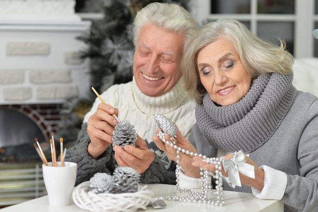 Portrait of happy senior couple se préparant pour Noël à la maison