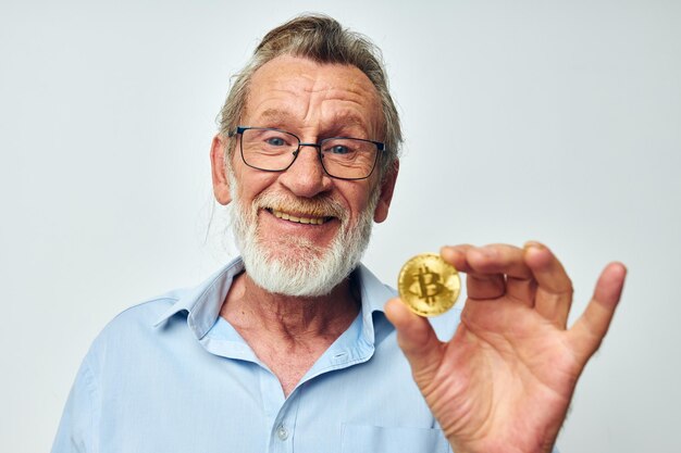 Portrait of happy senior man finance des pièces d'or bitcoin posant inchangé