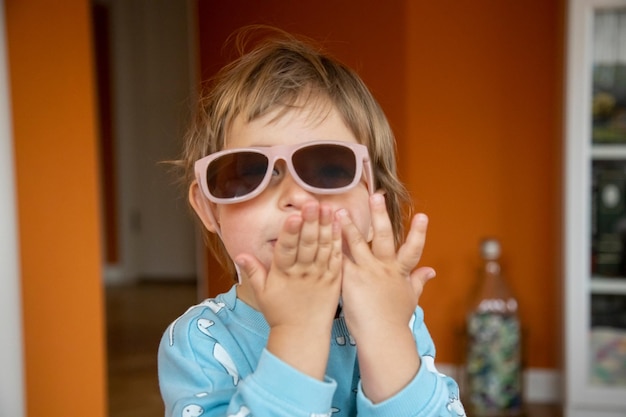 Portrait of happy smiling adorable tout-petit dans des lunettes de soleil pour bébé enfant joyeux envoyant un baiser d'air