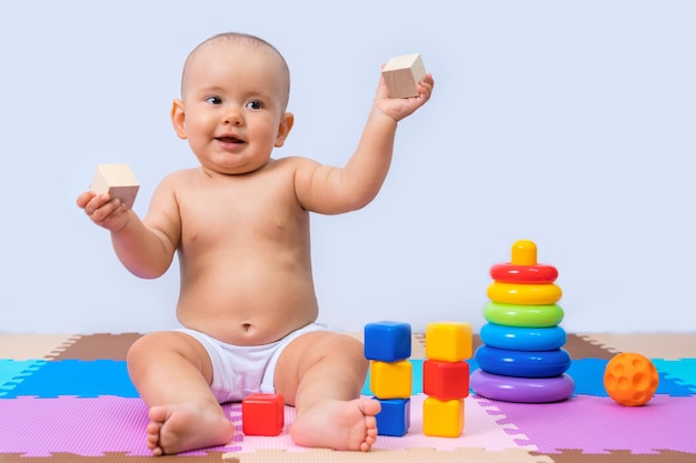 Portrait of happy smiling baby 8-12 mois dans la salle de jeux sur fond blanc