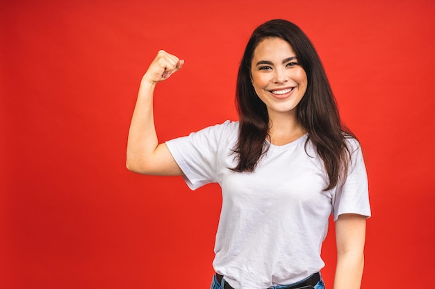 Portrait of happy smiling brunette girl in casual isolé sur fond rouge