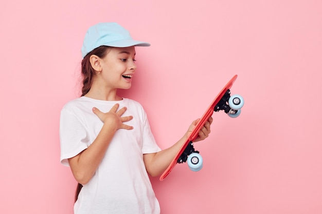 Portrait of happy smiling child girl cap in white tshirt skateboard Lifestyle inchangé