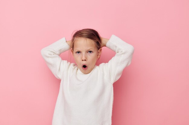 Portrait of happy smiling enfant fille chandail blanc posant fun style de vie inchangé