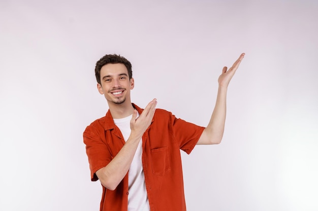 Portrait of happy smiling young man présentant et montrant votre texte ou produit isolé sur fond blanc