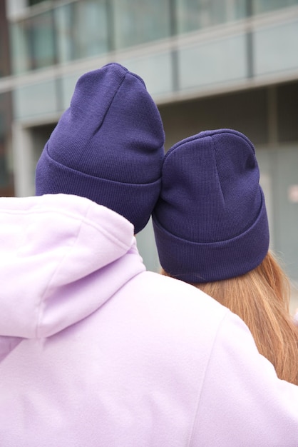 Portrait of happy young couple in hats outdoors posant des vêtements de style urbain