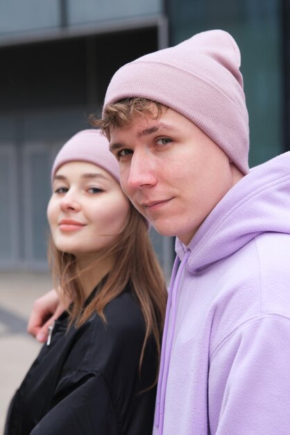 Portrait of happy young couple in hats outdoors posant des vêtements de style urbain