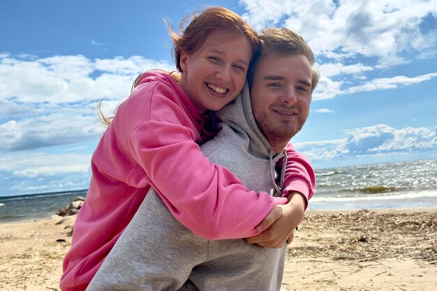 Portrait of happy young couple walk on the beach love hug l'autre mec porte sa petite amie