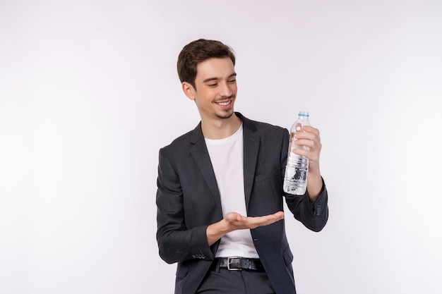 Portrait of Happy young man montrant de l'eau dans une bouteille isolé sur fond blanc