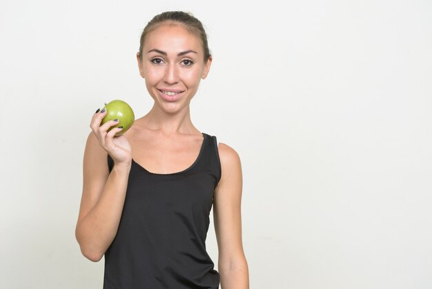 Portrait of happy young woman holding apple prêt pour la gym