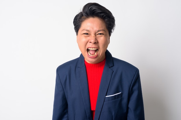 Portrait of mature asiatique garçon manqué businesswoman wearing suit contre le mur blanc