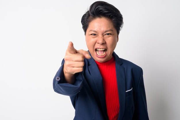 Portrait of mature asiatique garçon manqué businesswoman wearing suit contre le mur blanc