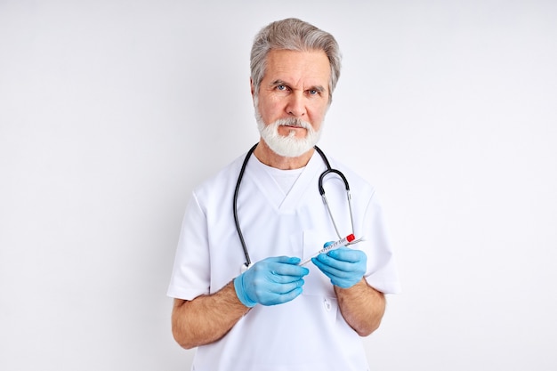 Portrait of mature doctor man avec tube d'échantillonnage du virus corona de la personne infectée en laboratoire