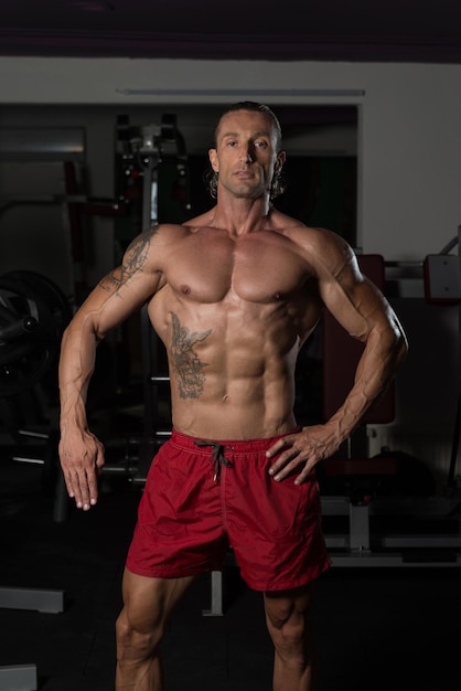 Portrait Of A Mature Physiquement Fit Tattoo Man Montrant Son Corps Bien Entraîné Muscular Athletic Bodybuilder Fitness Model Posing After Exercises