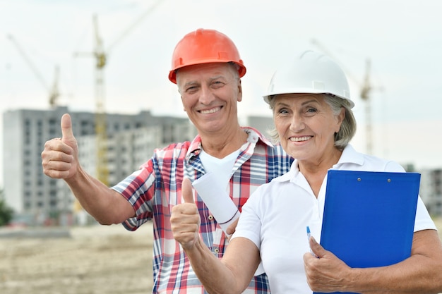 Portrait of senior couple en construction avec Thumbs up