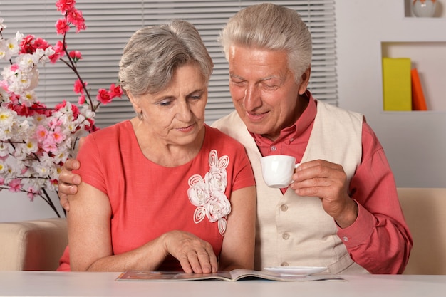 Portrait of senior couple lecture magazine à la maison