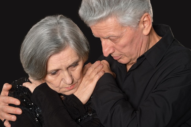 Portrait of senior couple triste sur fond sombre